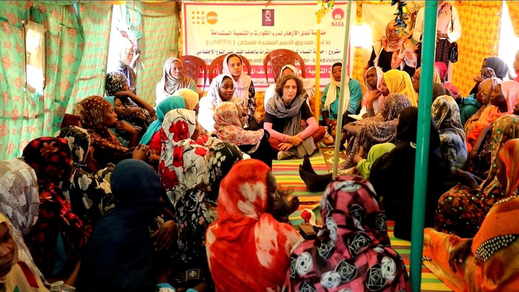 فابريزيا فالسيوني، ممثلة صندوق الأمم المتحدة للسكان في السودان (في الوسط)، تلتقي بالنازحات في مساحة آمنة في مخيم قوز السلام، ولاية النيل الأبيض، السودان.